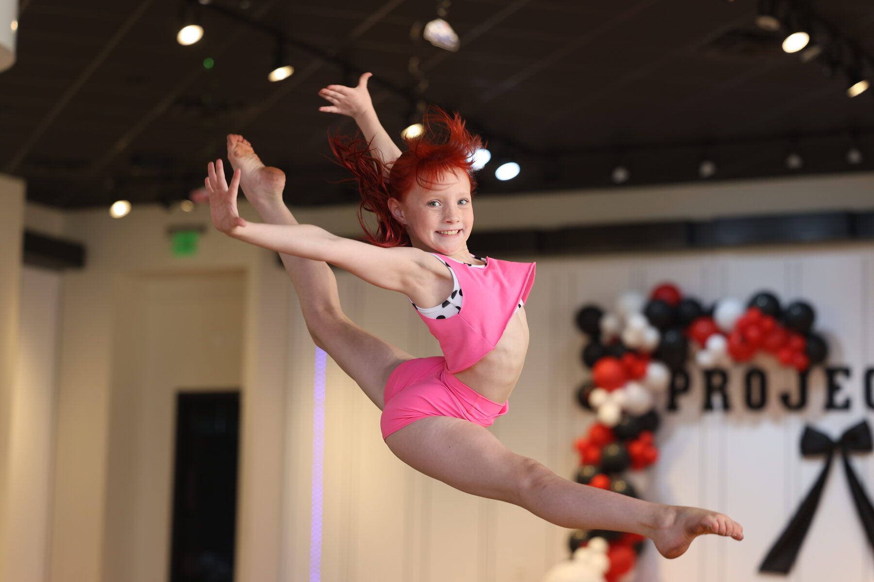 Competitive team dancer leaping on stage